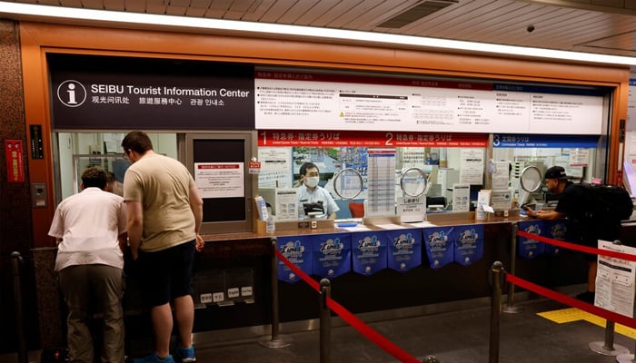 German tourist Kevin Khani and Austrian tourist Georg Riedlbaur use an automated translation window at the Seibu-Shinjuku station in Tokyo, Japan, July 26, 2023. — Reuters